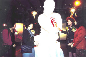 在汇丰银行总行地面广场举行「爱滋病十年回顾图片展览」，由前港督彭定康夫人为石膏像带上红丝带